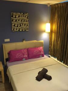 a bedroom with a bed with pink pillows at 7 Star Hotel in Kota Damansara