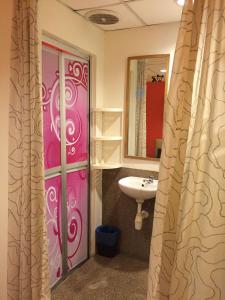 baño con puerta rosa y lavamanos en 7 Star Hotel, en Kota Damansara