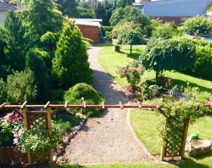 a garden with a wooden bridge and flowers at Haus Claudia in Schneverdingen +4 photos