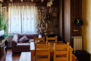 a living room with a couch and a table and chairs at Casa Rural el Sastre in Navaleno