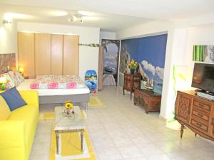 a living room with a yellow couch and a tv at Monte Carvoeiro Studio in Carvoeiro