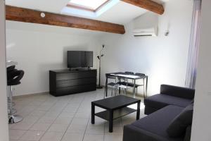 a living room with a couch and a tv at Residence Villa Ange in La Seyne-sur-Mer