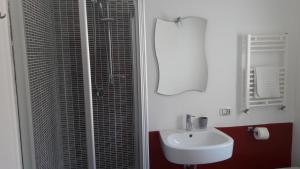 a white bathroom with a sink and a shower at House Il Conte in Palermo