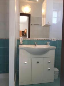 W łazience znajduje się umywalka, lustro i toaleta. w obiekcie La Quiete degli Dei w mieście Agerola