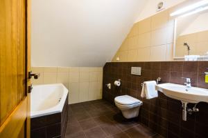 La salle de bains est pourvue de toilettes, d'un lavabo et d'une baignoire. dans l'établissement Penzion U Barana, à Trojanovice