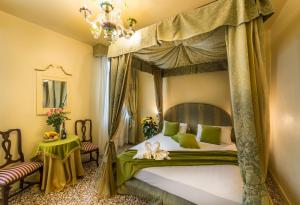 1 dormitorio con cama con dosel y colcha verde en Alloggi Acquavita - checkin at "Alloggi SS Giovanni e Paolo", en Venecia