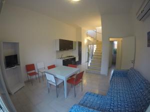 Itaca Residence Marsala في مارسالا: مطبخ وغرفة طعام مع طاولة وكراسي