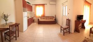 a kitchen and a living room with a couch and a table at Eirini- Ioanna in Sami