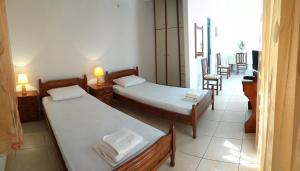 a room with two beds and a table and chairs at Eirini- Ioanna in Sami