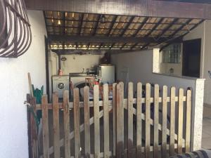 a wooden picket fence in front of a kitchen at Refugio de Praia em Saquarema in Saquarema