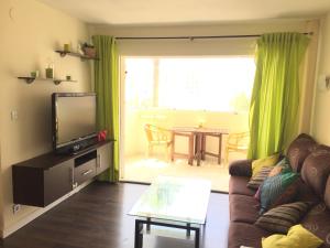 a living room with a couch and a television and a table at Apartment Erisa in Torremolinos