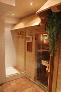 uma casa de banho com um chuveiro e uma banheira num quarto em Hotel & Restaurant Grüner Baum - Die Grüne Oase Am Feldberg em Feldberg