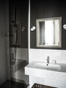 a bathroom with a sink and a shower with a mirror at Camellas-Lloret in Montréal