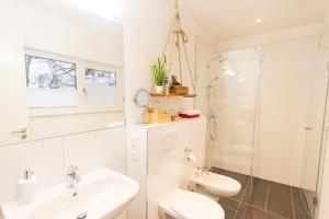 a white bathroom with a sink and a toilet at Refugium auf Usedom in Ostseebad Karlshagen