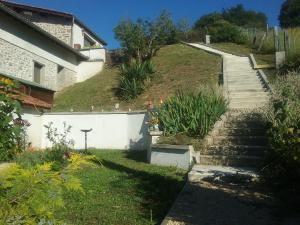 un escalier menant à une maison avec une colline herbeuse dans l'établissement Gîte Le Chapis, à Saint-Chamond
