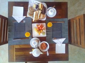 a wooden table with breakfast foods on it at Kuwera Eco Lodge in Sigiriya