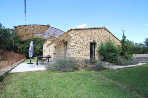 a patio with a table and a brick building at La Caprine in Gordes