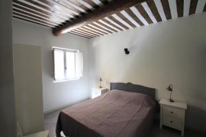 a bedroom with a bed and a window at La Caprine in Gordes