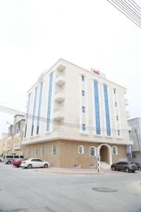 a large building with cars parked in front of it at Golden Season Furnished Apartments 5 in Salalah