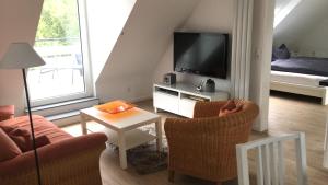 salon z 2 krzesłami i telewizorem w obiekcie Ferienwohnung Niederrhein w mieście Rheurdt