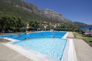 uma grande piscina com uma montanha ao fundo em Barbati Pietre Di Mare em Barbati