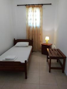 a bedroom with a bed and a bench in it at Eirini- Ioanna in Sami