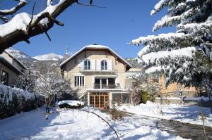 ein Haus im Schnee mit schneebedeckten Bäumen in der Unterkunft Villa Le Gai Soleil in Embrun