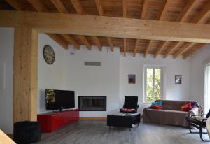 sala de estar con sofá y TV en Villa Le Gai Soleil, en Embrun