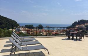 a row of chairs and a table on a balcony at Canary Studios in Parga
