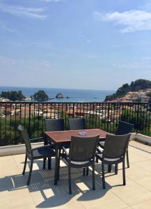 a wooden table and chairs on a balcony with the ocean at Canary Studios in Parga