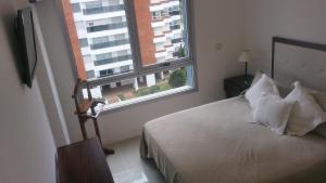 1 dormitorio con cama y ventana grande en Edificio Forest Tower 2, en Punta del Este