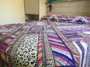 トレモリノスにあるApartment Erisaのカラフルなベッド(カラフルな掛け布団付)