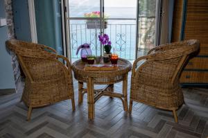 a table and two chairs with drinks on a balcony at B&B Sunshine in Scilla