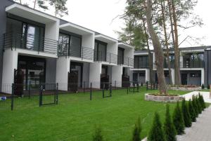 a building with a grass yard in front of it at KAMI Ferienwohnungen in Pobierowo