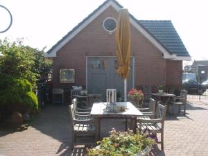 a patio with a table and an umbrella at Logement Brocante in De Koog