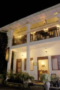 a large white building with plants in front of it at Pedlar 62 Guest House in Galle