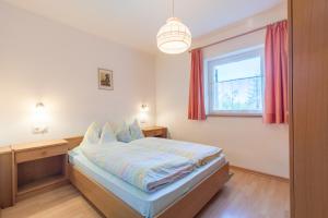 sypialnia z łóżkiem i oknem w obiekcie Appartements Haus Pichler w mieście Eggen