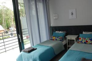 two beds in a room with a window at KAMI Ferienwohnungen in Pobierowo +27 photos
