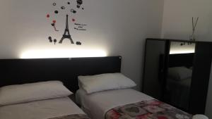 a bedroom with two beds and a clock on the wall at La casetta di Jasmine in Salerno