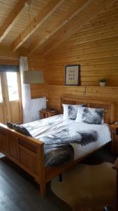 een slaapkamer met een groot bed in een blokhut bij De Priesnitzhoeve in Laag-Soeren