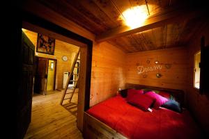 1 dormitorio con 1 cama roja en una habitación de madera en Domačija Koklej - Apartments Vintage Vacation, en Luče