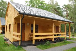 a large wooden cabin with a pitched roof at AURUM Domki Letniskowe in Pogorzelica