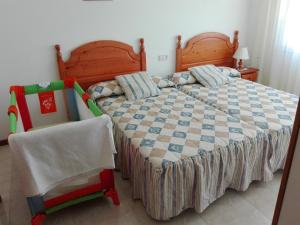 ein Schlafzimmer mit einem Bett und einem Stuhl in der Unterkunft Apartamentos Esther in Sanxenxo