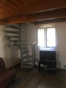 ein Wohnzimmer mit einer Treppe und einem TV in der Unterkunft Villa Mer Et Montagne in Macinaggio