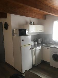 eine Küche mit einem weißen Kühlschrank und einer Mikrowelle in der Unterkunft Villa Mer Et Montagne in Macinaggio