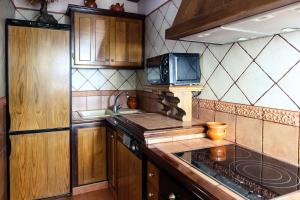 a kitchen with wooden cabinets and a stove top oven at Casa Rural el Sastre in Navaleno