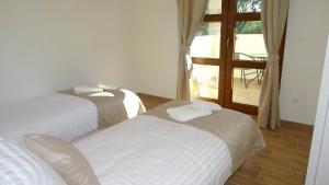 two beds in a room with a view of a patio at Villa Anna - 4 bedrooms, 4 bathrooms, heated pool, jacuzzi in Kornić +36 photos