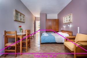 1 dormitorio con 1 cama, mesa y sillas en Irinoula Dreams, en Kolimvárion