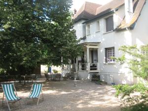 zwei Stühle vor einem weißen Haus in der Unterkunft Villa PHILIS in Bergerac