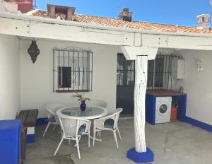 a patio with a table and chairs and a washing machine at Casa Azul in Bolonia